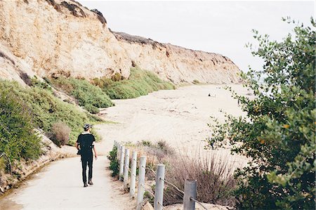 Rear view of male photographer strolling to beach, Crystal Cove State Park, Laguna Beach, California, USA Photographie de stock - Premium Libres de Droits, Code: 614-08544952