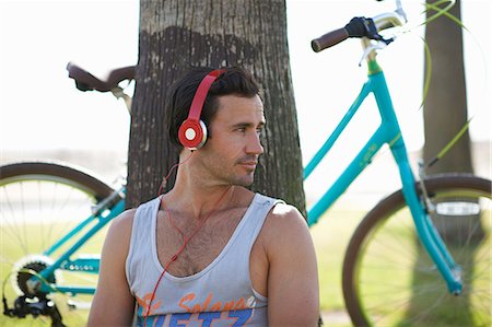 simsearch:841-03502611,k - Male cyclist sitting listening to headphone music at Venice Beach, Los Angeles, California, USA Foto de stock - Sin royalties Premium, Código: 614-08544991