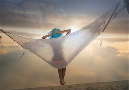 female only - Rear view of young woman lying on hammock at sunset, Miami beach, Florida, USA Stock Photo - Premium Royalty-Free, Code: 614-08578277