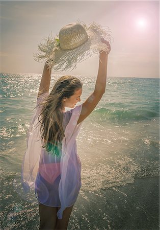 simsearch:851-02964108,k - Beautiful young woman holding up sunhat on Miami beach, Florida, USA Foto de stock - Sin royalties Premium, Código: 614-08578280