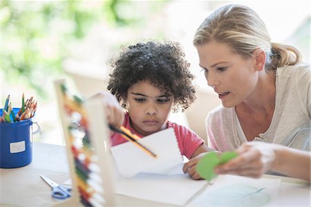 simsearch:649-08576682,k - Mother and son sitting at table, boy using scissors Fotografie stock - Premium Royalty-Free, Codice: 614-08578449