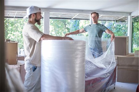 simsearch:614-03648212,k - Moving house: two unrolling bubble wrap in preparation for packing Stock Photo - Premium Royalty-Free, Code: 614-08578485