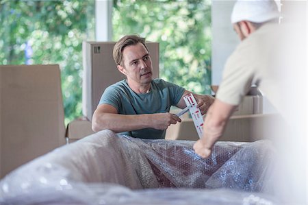 simsearch:614-01170983,k - Moving house: two men wrapping sofa in bubble wrap Photographie de stock - Premium Libres de Droits, Code: 614-08578487