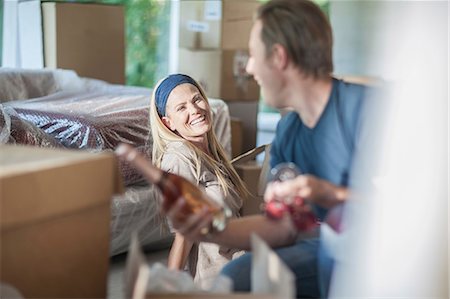 picture of champagne bottle and champagne flute - Moving house: couple in room with cardboard boxes, man holding bottle of champagne and champagne flutes Stock Photo - Premium Royalty-Free, Code: 614-08578494