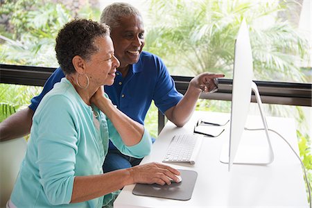 Senior couple sitting at table, using computer Stock Photo - Premium Royalty-Free, Code: 614-08578606