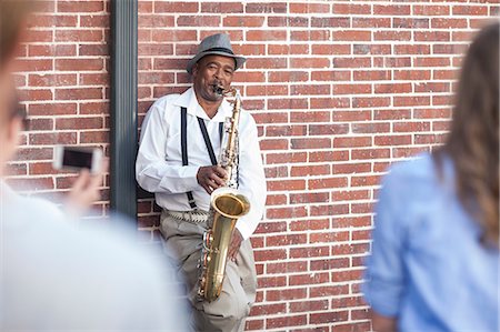 Pedestrian throwing money into street musician's music case, low section Fotografie stock - Premium Royalty-Free, Codice: 614-08578638