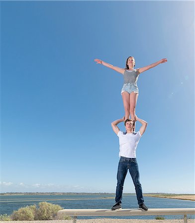 Couple practising partner yoga on beach bench Foto de stock - Sin royalties Premium, Código: 614-08578703