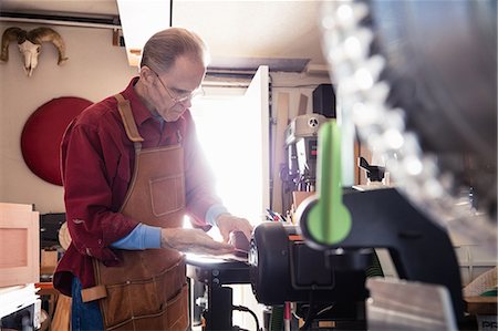 Senior man working on carpentry equipment in workshop Foto de stock - Sin royalties Premium, Código: 614-08578729