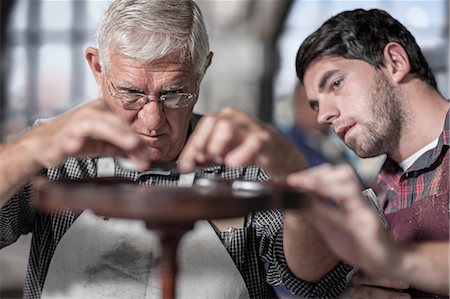 simsearch:649-07905311,k - Senior craftsman showing trainee table restoration in antique restoration workshop Photographie de stock - Premium Libres de Droits, Code: 614-08578783