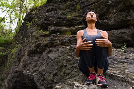 simsearch:614-08867592,k - Woman sitting hugging knees on rock meditating Photographie de stock - Premium Libres de Droits, Code: 614-08641267