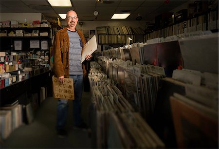 simsearch:614-08641282,k - Portrait of mature man in record shop, holding records Photographie de stock - Premium Libres de Droits, Code: 614-08641275