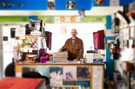 retro glasses - Portrait of mature man in record shop, leaning on stack of records Stock Photo - Premium Royalty-Free, Code: 614-08641285