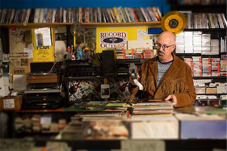 simsearch:614-08641283,k - Mature man in record shop, pricing up records using price gun Photographie de stock - Premium Libres de Droits, Code: 614-08641281