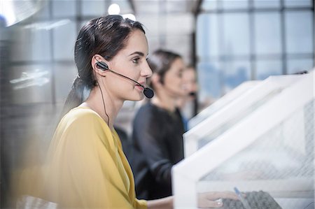 Row of female telephonists advising in call centre Stock Photo - Premium Royalty-Free, Code: 614-08641473
