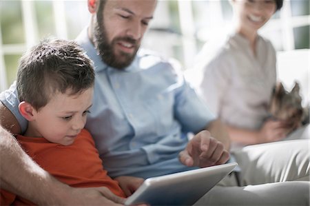 simsearch:614-08641537,k - Father and son using digital tablet, mother with pet dog in background Photographie de stock - Premium Libres de Droits, Code: 614-08641530