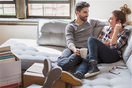 Moving house: Young couple relaxing on sofa surrounded by cardboard boxes Stock Photo - Premium Royalty-Free, Code: 614-08641566