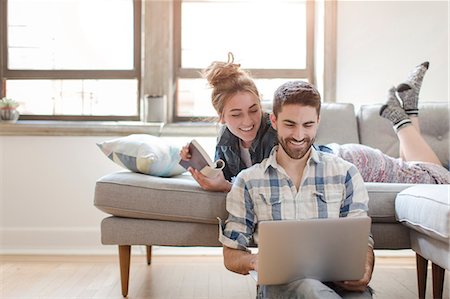 relaxing at home - Young couple relaxing at home, looking at laptop Stock Photo - Premium Royalty-Free, Code: 614-08641562