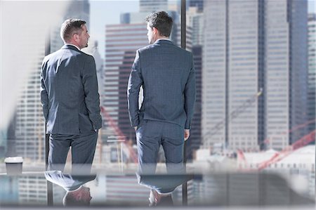 photos of man backside - Businessmen in discussion in front of office window Stock Photo - Premium Royalty-Free, Code: 614-08641612