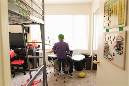 Boy playing drums in bedroom Fotografie stock - Premium Royalty-Free, Codice: 614-08641626