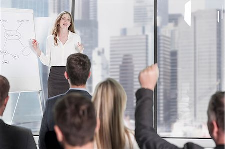 professional woman sitting focused - Businesswoman presenting at brainstorming session in office Stock Photo - Premium Royalty-Free, Code: 614-08641623