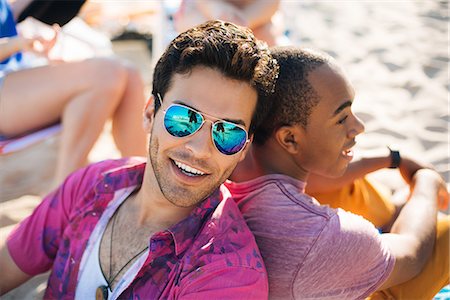 portrait sunglasses - Portrait of two men sitting back to back on beach, Santa Monica, California, USA Stock Photo - Premium Royalty-Free, Code: 614-08641662