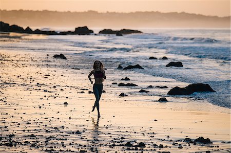 simsearch:614-08383692,k - Silhouetted female runner running at sunset on beach, Los Angeles, California, USA Foto de stock - Sin royalties Premium, Código: 614-08641707