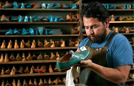 shoes wearing man - Male cobbler in traditional shoe shop polishing green brogue Stock Photo - Premium Royalty-Free, Code: 614-08641753