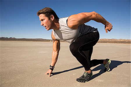 simsearch:614-08578789,k - Male runner on his marks on dry lake bed, El Mirage, California, USA Foto de stock - Sin royalties Premium, Código: 614-08641808