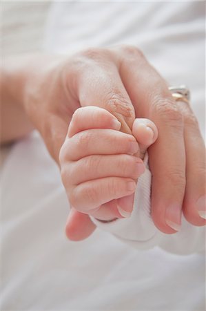 fingering mom photo - Mothers hand holding baby boys hand Stock Photo - Premium Royalty-Free, Code: 614-08684707