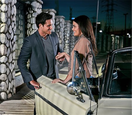 Man helping woman out of classic car at night, Los Angeles, California, USA Stock Photo - Premium Royalty-Free, Code: 614-08684726