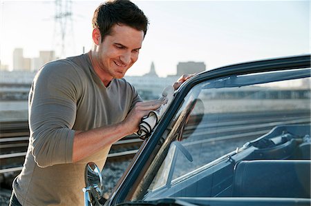 Man polishing car smiling, Los Angeles, California, USA Stock Photo - Premium Royalty-Free, Code: 614-08684739