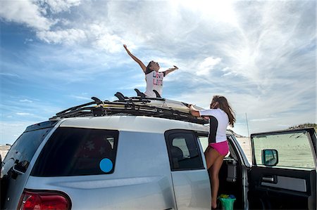 sister tying - Two young girls untying surfboards from top of car Stock Photo - Premium Royalty-Free, Code: 614-08684809