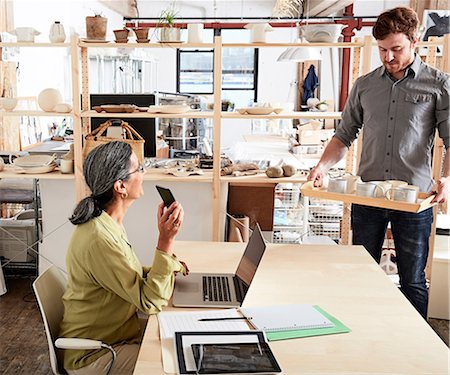 Man showing colleague tray of ceramics Stock Photo - Premium Royalty-Free, Code: 614-08684826