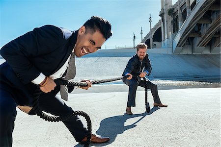 Businessman doing tug of war with rope, Los Angeles river, California, USA Stock Photo - Premium Royalty-Free, Code: 614-08684918