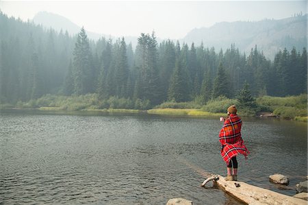 Woman wrapped in tartan blanket drinking coffee by misty lake, Mount Hood National Forest, Oregon, USA Photographie de stock - Premium Libres de Droits, Code: 614-08684994