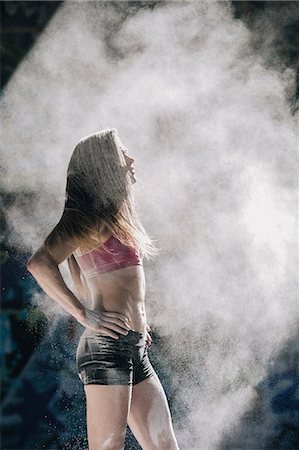 simsearch:614-08685097,k - Powder covered woman standing with hands on hips in cloud of dust Fotografie stock - Premium Royalty-Free, Codice: 614-08685104