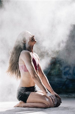 simsearch:614-08685103,k - Powder covered woman kneeling smiling in cloud of dust Stock Photo - Premium Royalty-Free, Code: 614-08685100