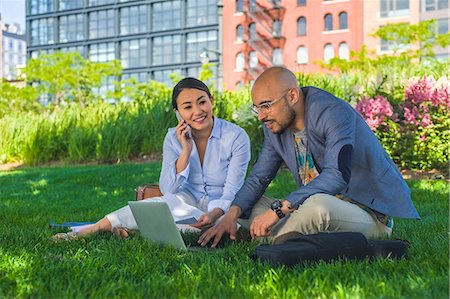 Businessman and woman sitting outdoors on grass, using laptop Stock Photo - Premium Royalty-Free, Code: 614-08685164