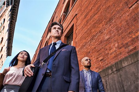 Businessmen and women walking outdoors, low angle view Stock Photo - Premium Royalty-Free, Code: 614-08685173