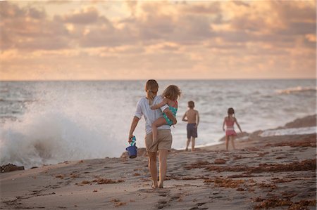 swimming suits for 12 years old girls - Mother carrying daughter on beach at sunrise, Blowing Rocks Preserve, Jupiter Island, Florida, USA Stock Photo - Premium Royalty-Free, Code: 614-08685220