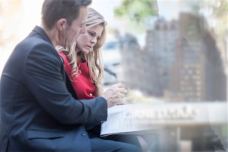 Businessman and woman reading newspaper and chatting in city park Stock Photo - Premium Royalty-Free, Code: 614-08685242