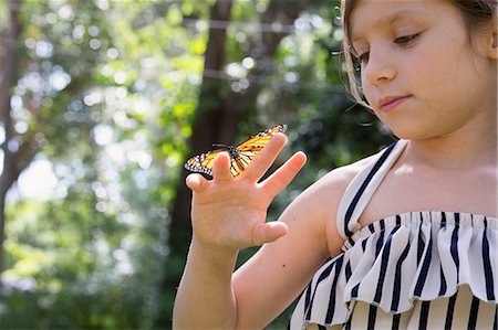 Girl holding monarch butterfly on finger Stock Photo - Premium Royalty-Free, Code: 614-08685275