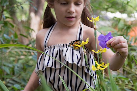 Girl looking at monarch butterfly on flower Photographie de stock - Premium Libres de Droits, Code: 614-08685271