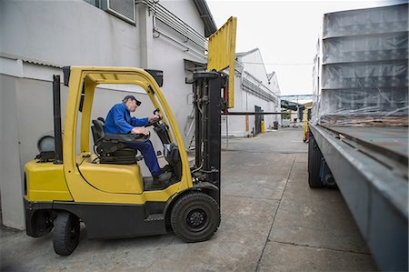 salopette - Forklift driver loading pallet onto truck at packaging factory Photographie de stock - Premium Libres de Droits, Code: 614-08726508