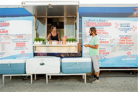 simsearch:614-08726534,k - Man standing beside fast food trailer speaking to woman inside trailer Stock Photo - Premium Royalty-Free, Code: 614-08726541