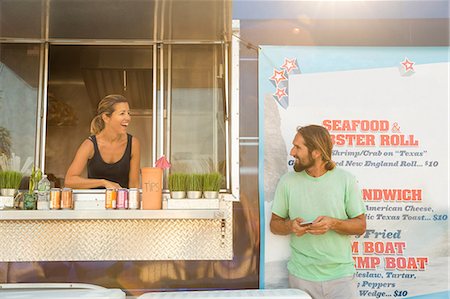 simsearch:614-08726534,k - Man standing beside fast food trailer speaking to woman inside trailer Stock Photo - Premium Royalty-Free, Code: 614-08726542