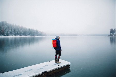 Hiker on snow covered pier looking at view of lake, Bass Lake, California, USA Photographie de stock - Premium Libres de Droits, Code: 614-08726636