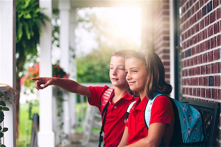 simsearch:614-08726632,k - Twin brother and sister sitting on bench pointing, on first day of new school year Fotografie stock - Premium Royalty-Free, Codice: 614-08726631