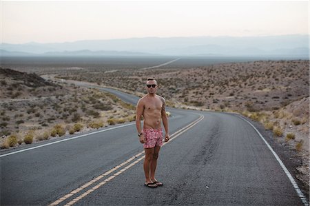 parque estatal del valle de fuego - Man wearing shorts and flip flops standing in road, Valley of Fire, Nevada, USA Foto de stock - Sin royalties Premium, Código: 614-08726645