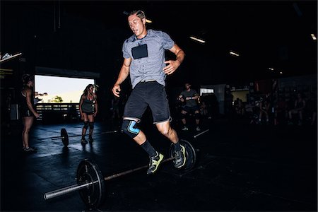 simsearch:649-09139139,k - Cross training athlete jumping over barbell in gym Stock Photo - Premium Royalty-Free, Code: 614-08726686